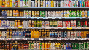 An array of drinks standing in supermarket shelf.