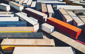 A view of freight containers on trucks, parked closely together.